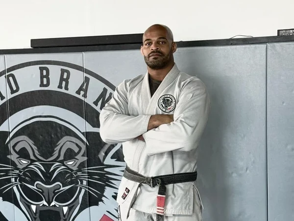 David Branch in a white gi with his arms folded at his academy